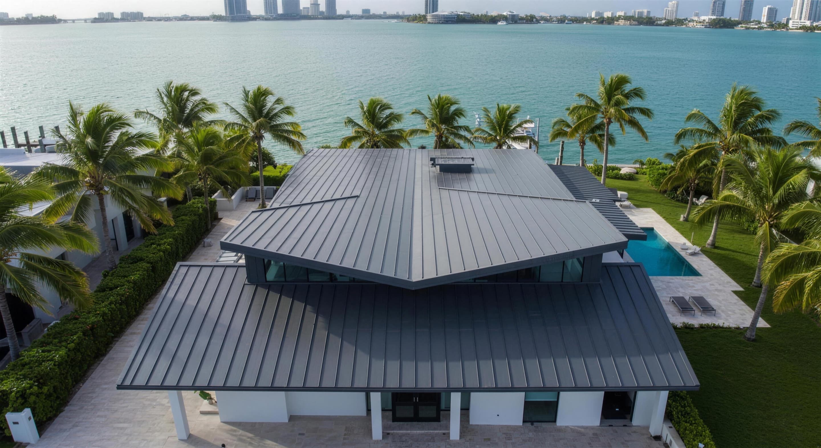 Aerial of a standing seam metal roof on Key Biscayne with the bay and skyline behind